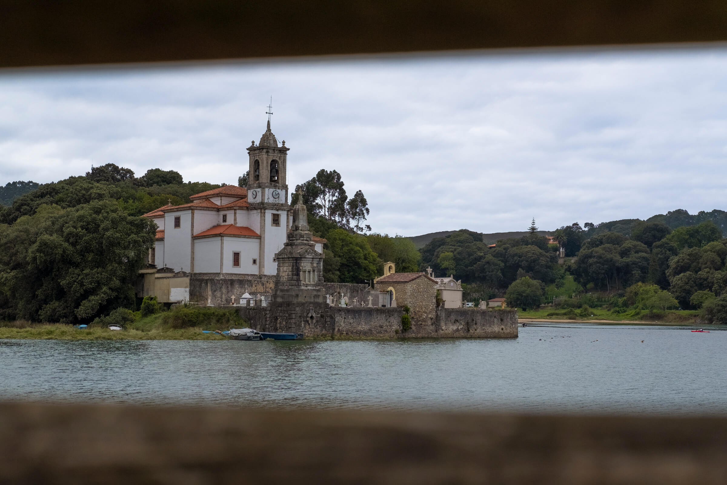 Cuando llegas a Niembro. Iglesia rodeada de árboles y agua
