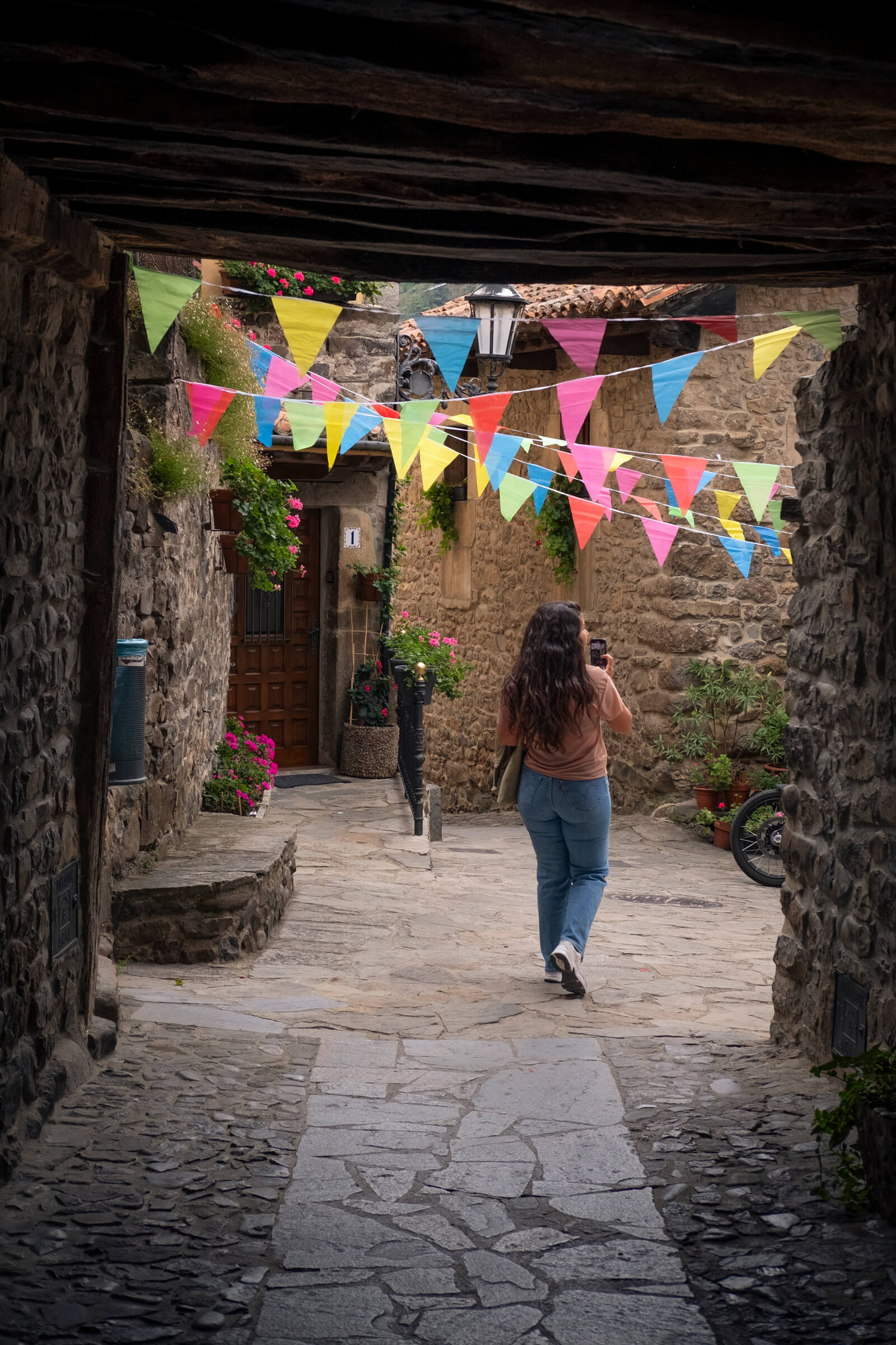 Recorriendo Potes en fiestas. Laura caminando por las calles de Potes, adornadas con banderines de colores por las fiestas del pueblo