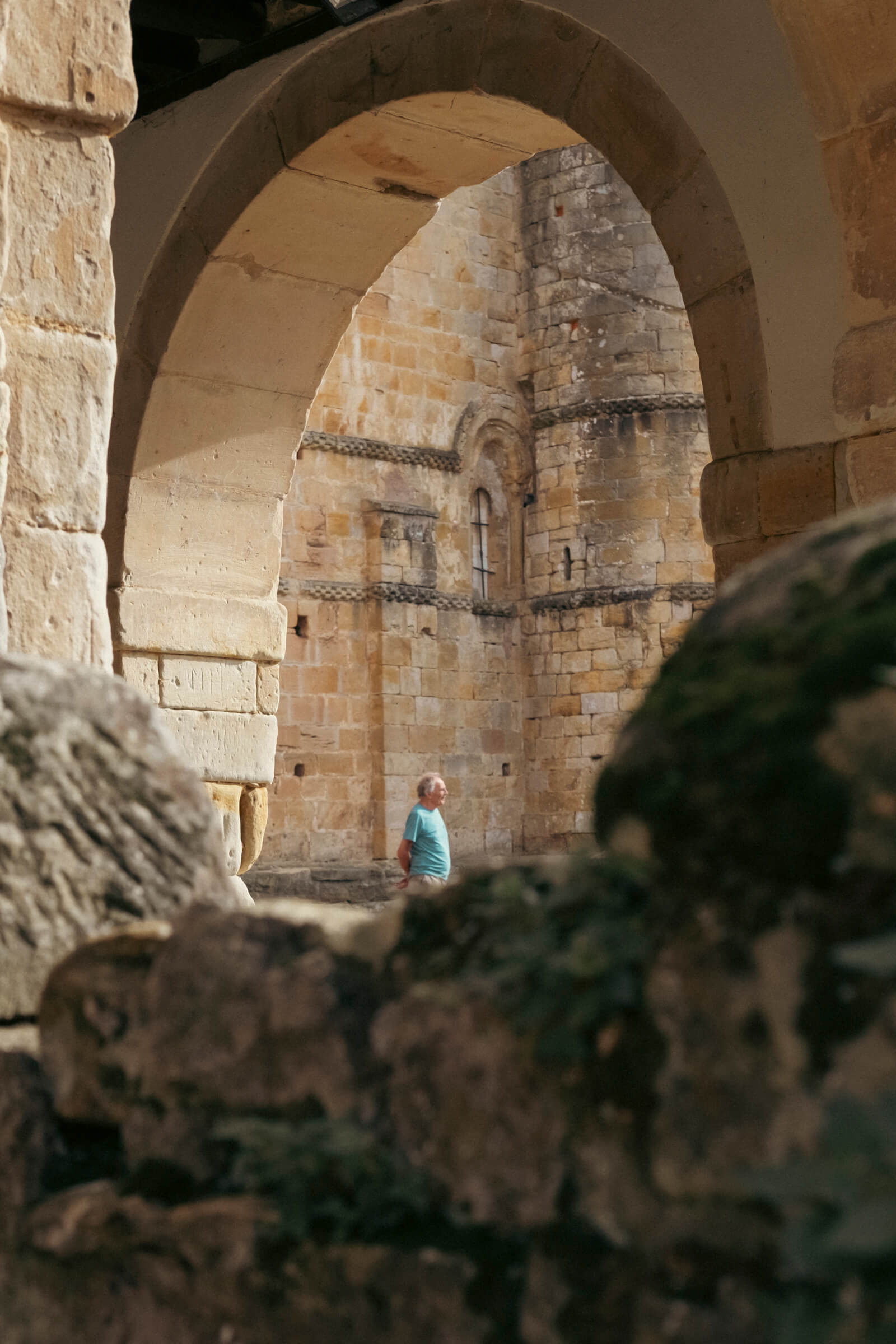 Santillana del Mar. Construcciones antiguas encuadran a un señor quieto en una plaza del pueblo observando la zona