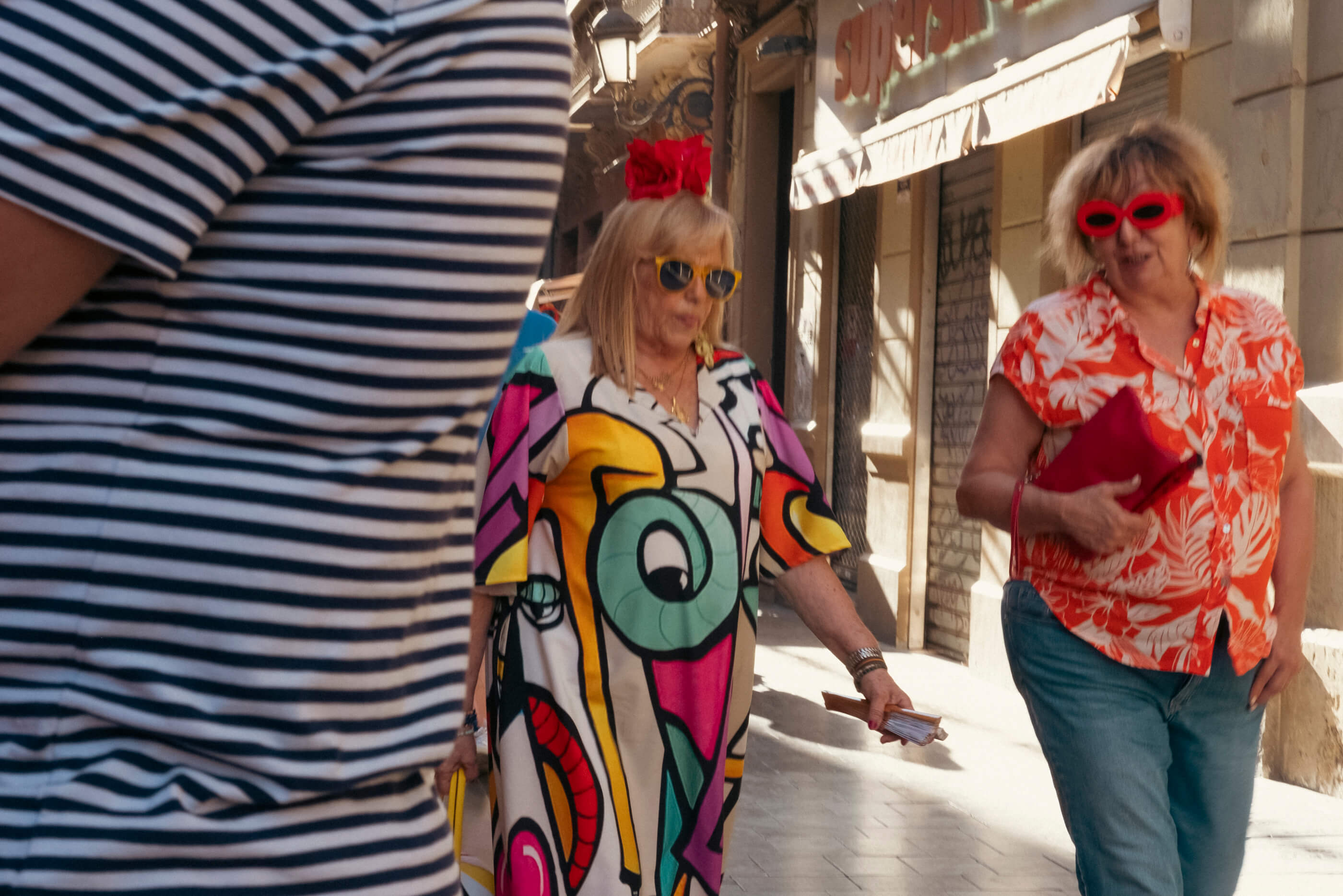 El color es alegría. Dos señoras caminando con vestidos muy coloridos