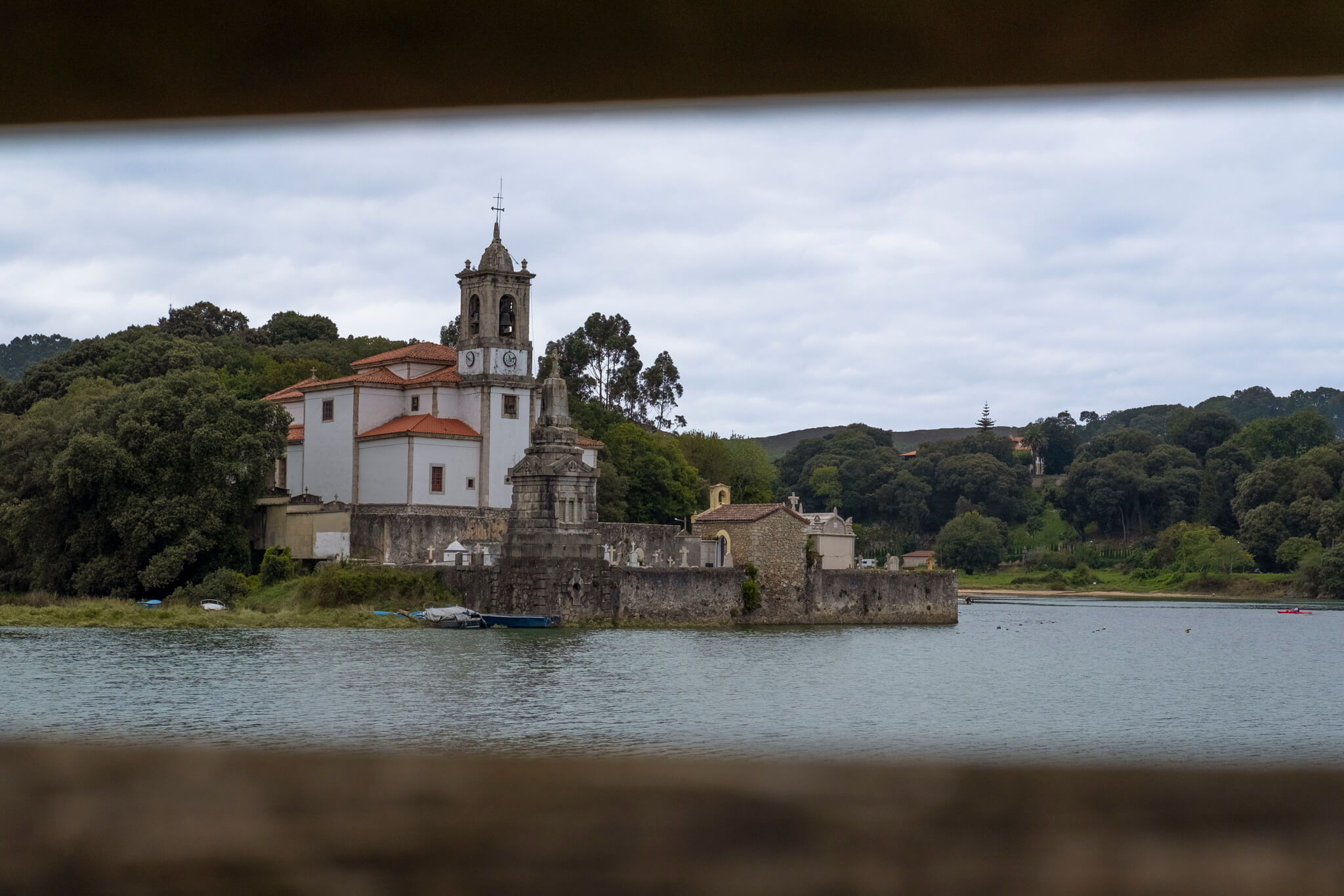 Cuando llegas a Niembro. Iglesia rodeada de árboles y agua