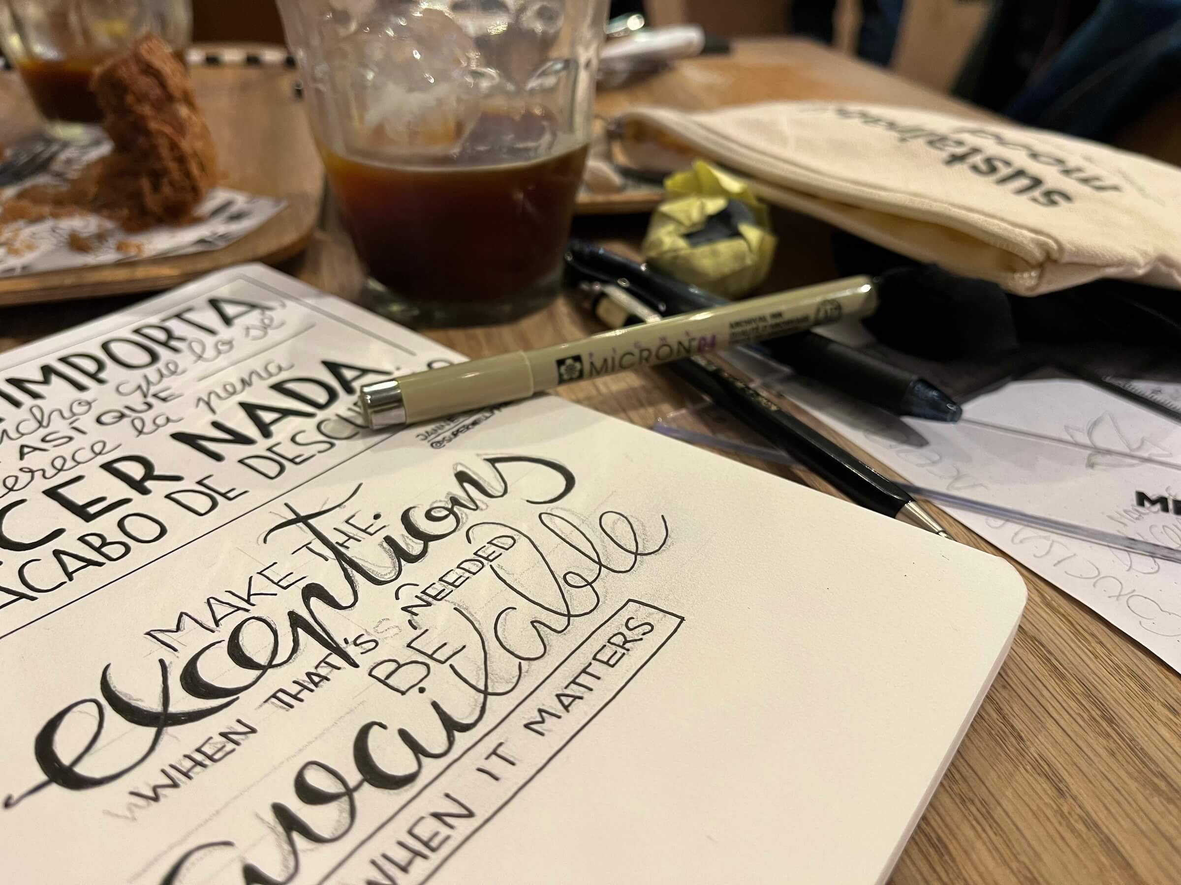 Escribiendo la cita en el cuaderno en una cafetería. Foto del cuaderno sobre la mesa, abierto con la página en la que está manuscrita la cita de la semana
