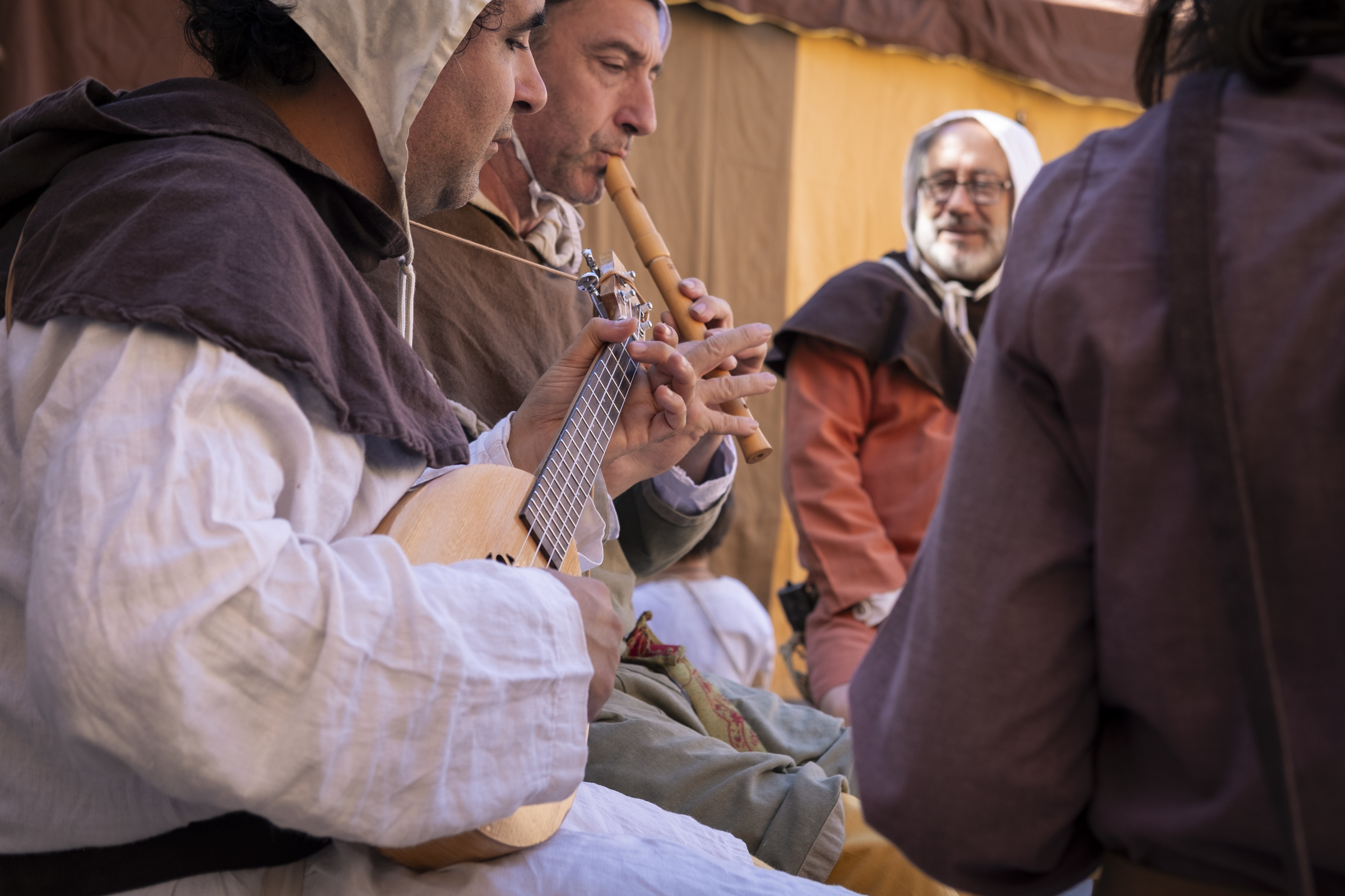 Diversión medieval. Un grupo de hombres vestidos como en la Edad Media disfrutando de un ratito de música en grupo.