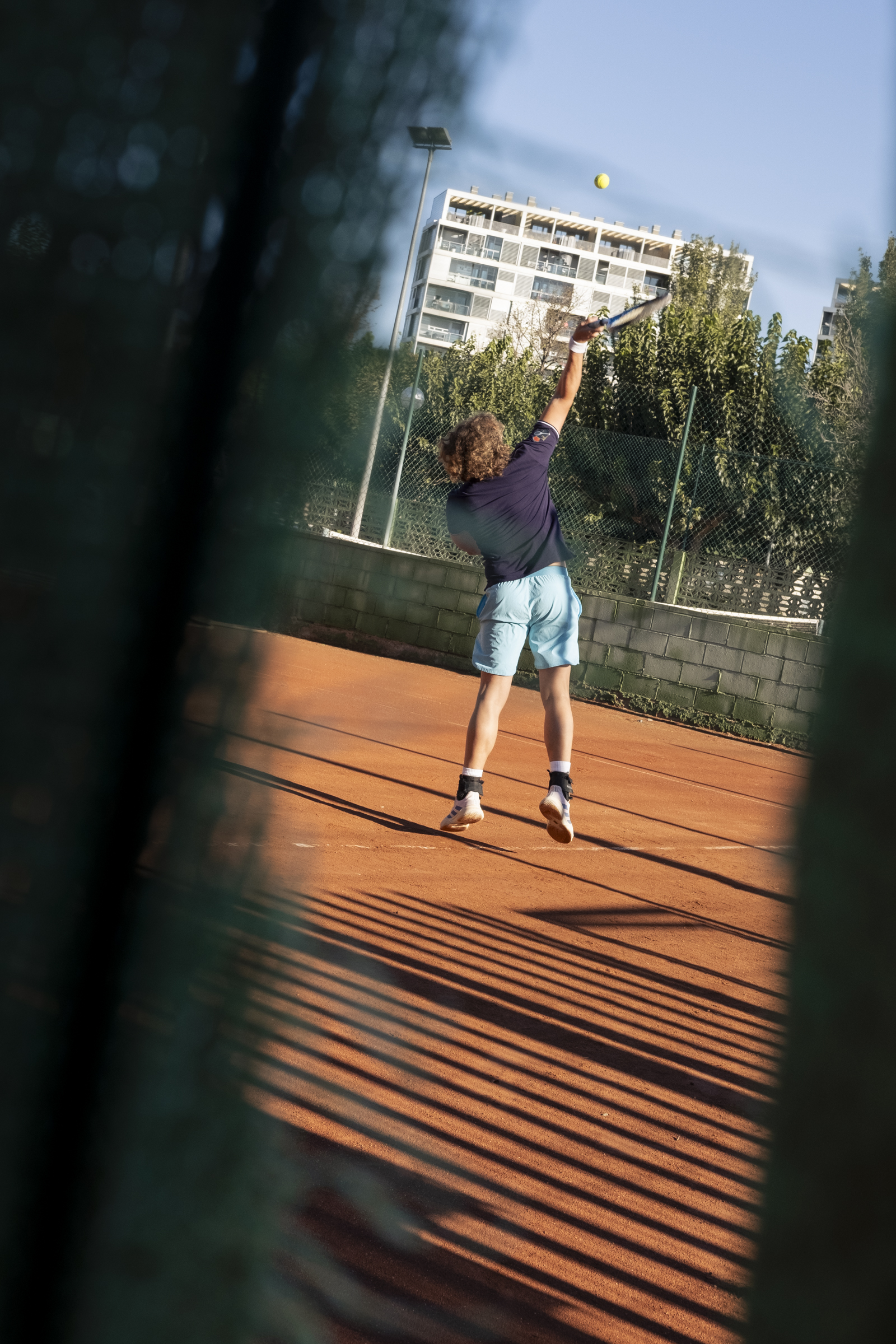 Tenista. Un tenista lanza la pelota al aire para el saque.