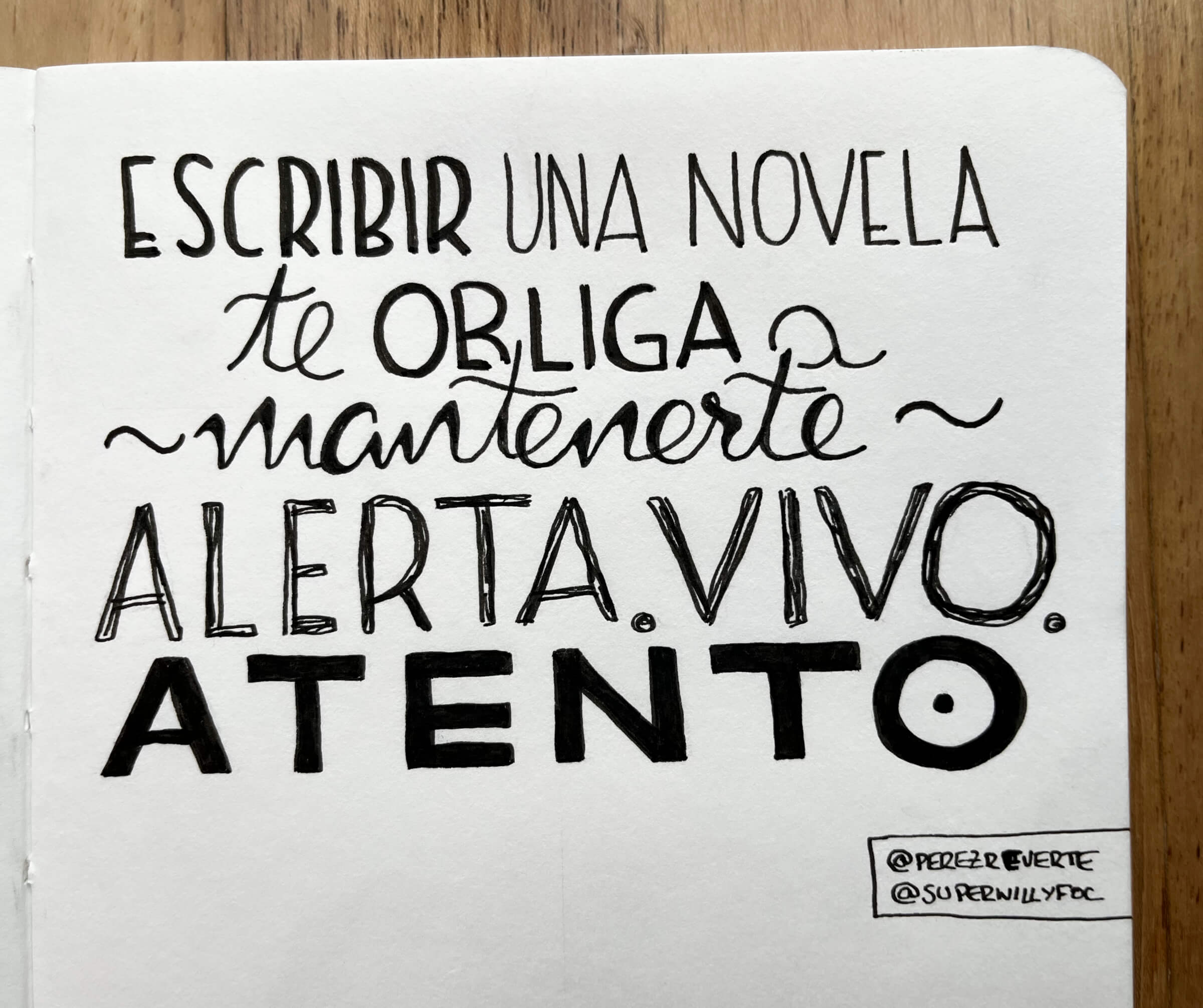 Foto de la cita manuscrita en el cuaderno. Foto de cita escrita manuscrita con la frase de Pérez Reverte: "Escribir una novela te obliga a mantenerte alerta, vivo, atento."