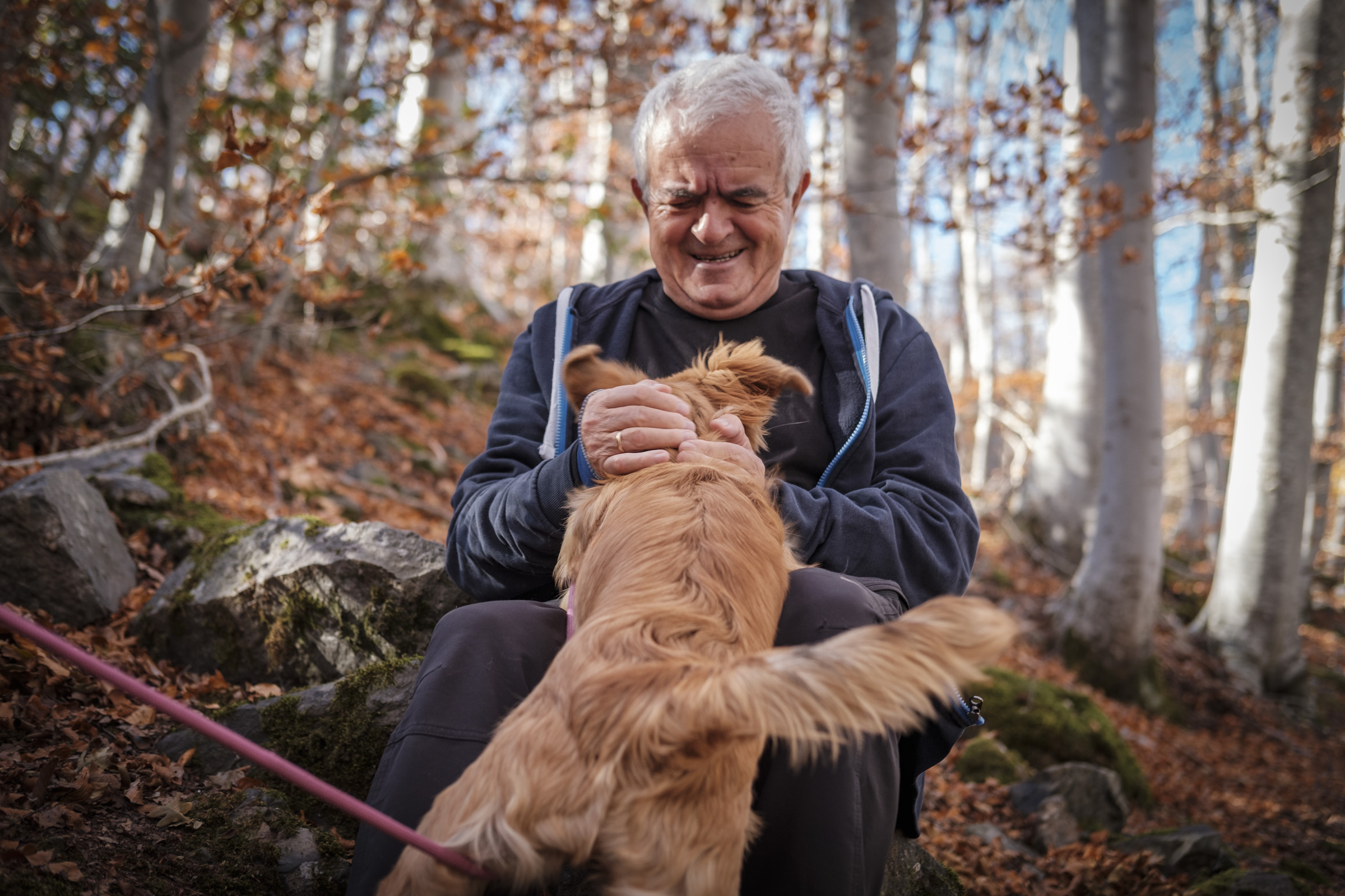 Mi padre jugando con Tosa en un camino del Moncayo. En primer plano mi padre, capturado justamente en un gesto de esfuerzo por estar enredando con una perra cachorra que demanda su atención
