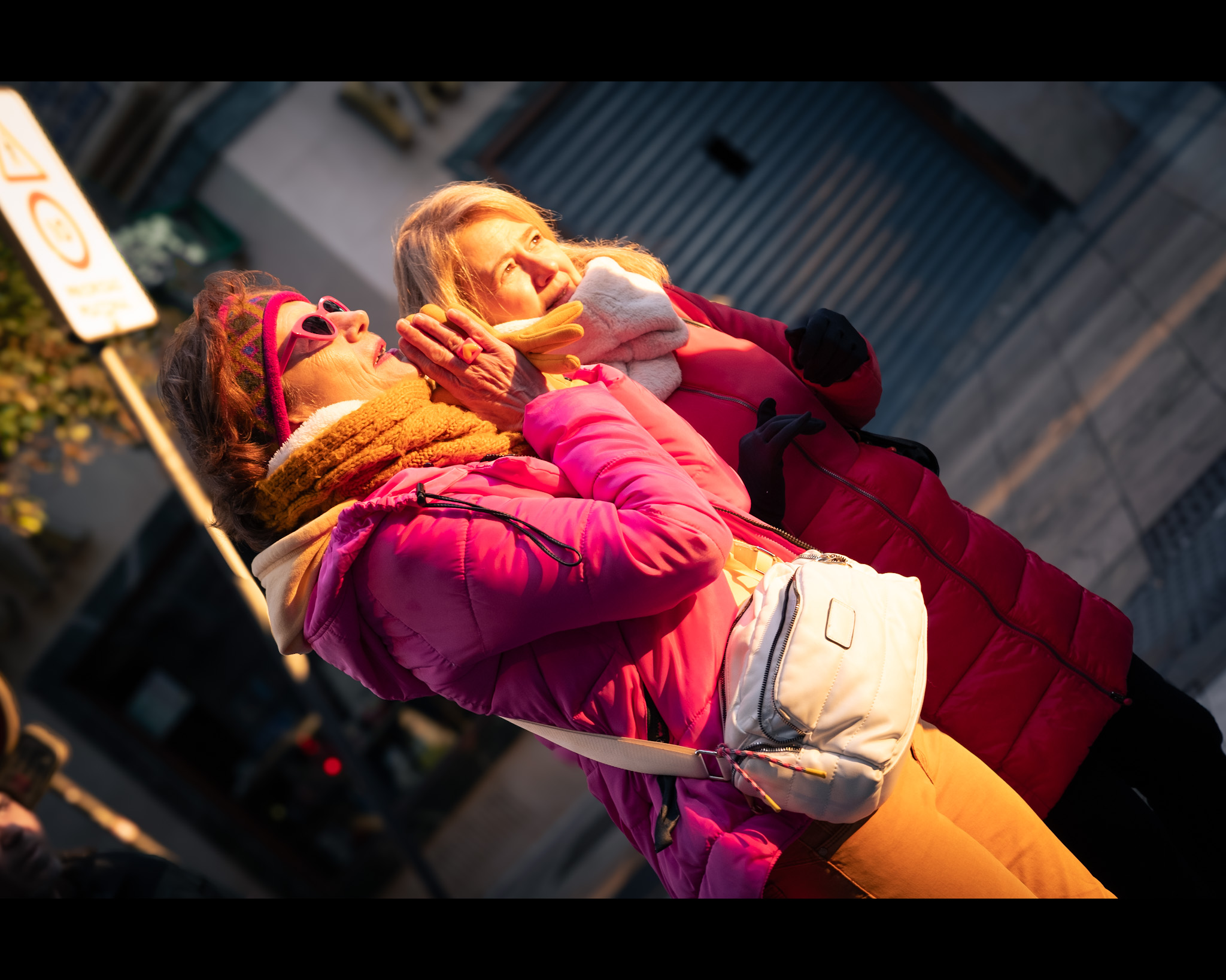 Señoras admirando el sol saliendo y alineándose con la calle mayor en el solsticio de invierno. Dos señoras, vestidas de forma muy colorida, mirando de frente al sol alineándose con la Calle Mayor en Zaragoza