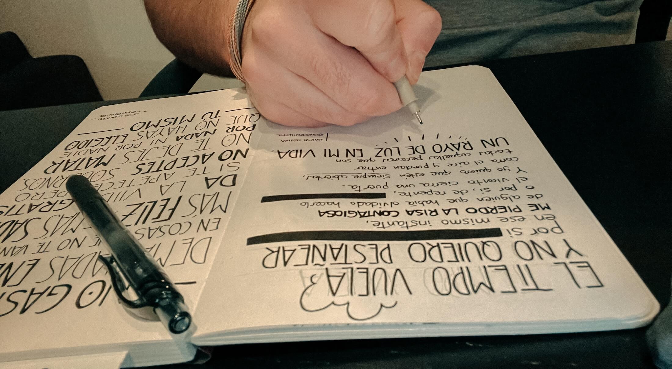 Foto del proceso de escritura en el cuaderno. Foto del cuaderno sobre la mesa con la cita a medio escribir