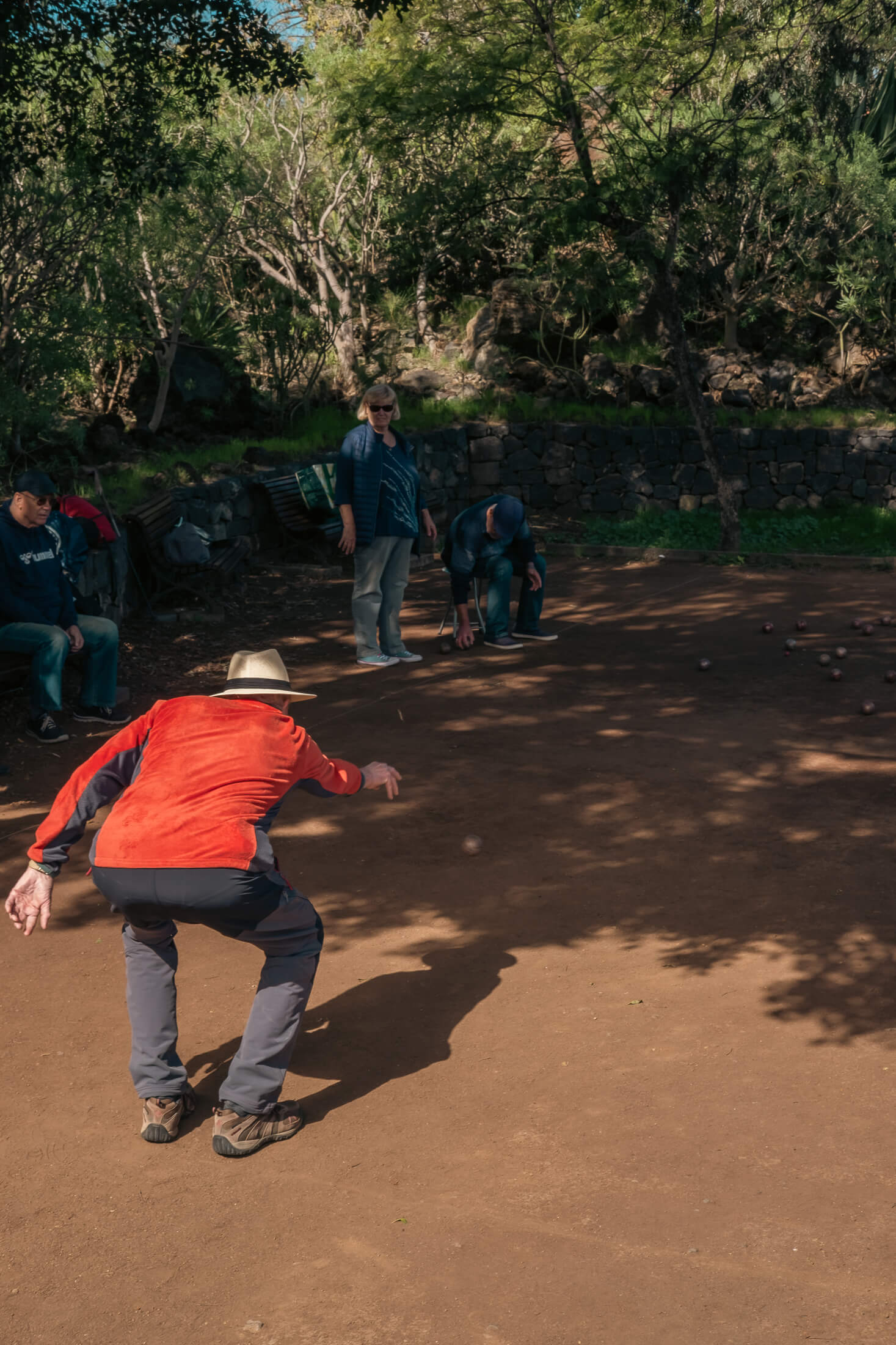 Jugador lanzando una bola de petanca durante una partida