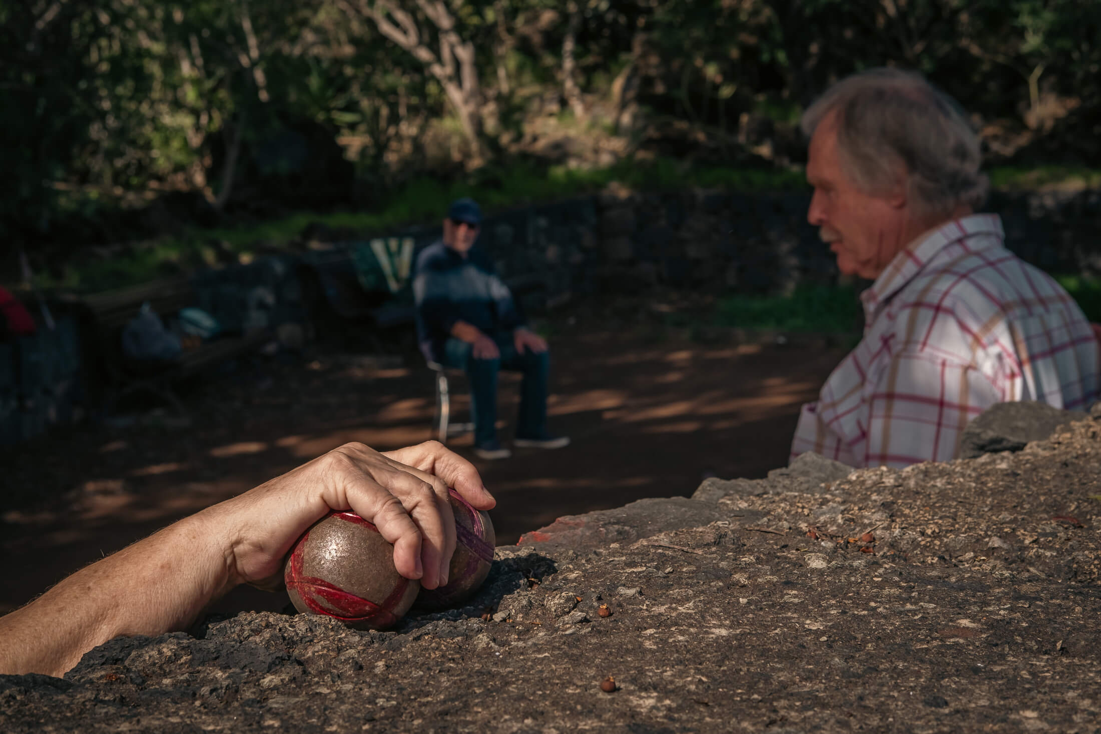 Jugador lanzando una bola de petanca durante una partida