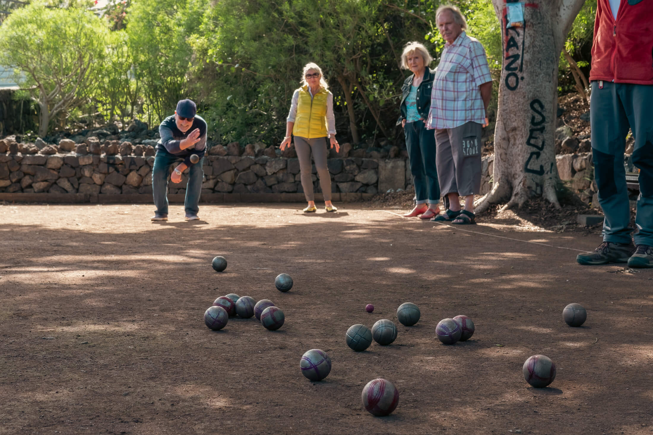 Jugador lanzando una bola de petanca durante una partida