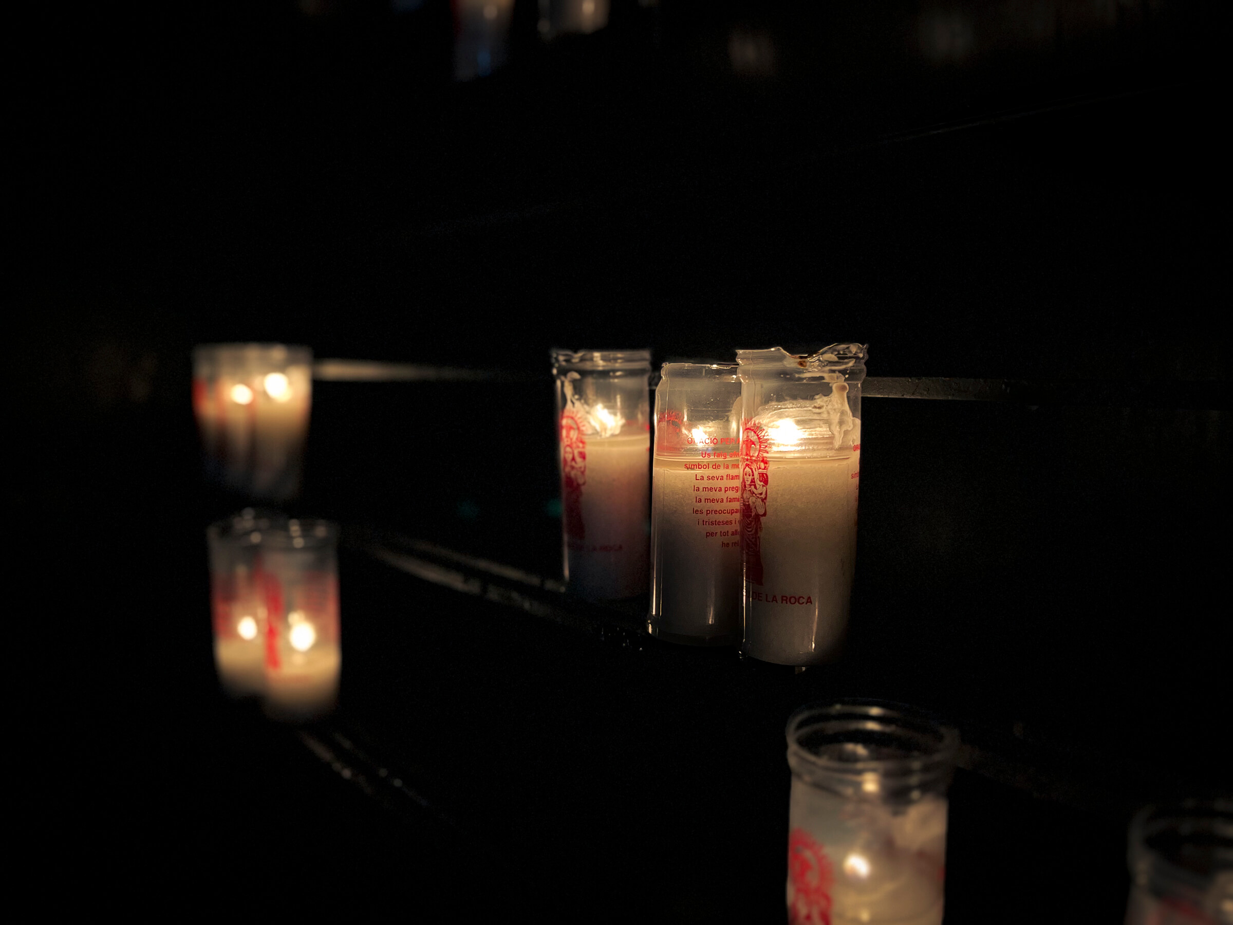 Probando una iluminación complicada de unas velas en la ermita. Primer plano de unas velas encendidas en medio de la oscuridad de la ermita
