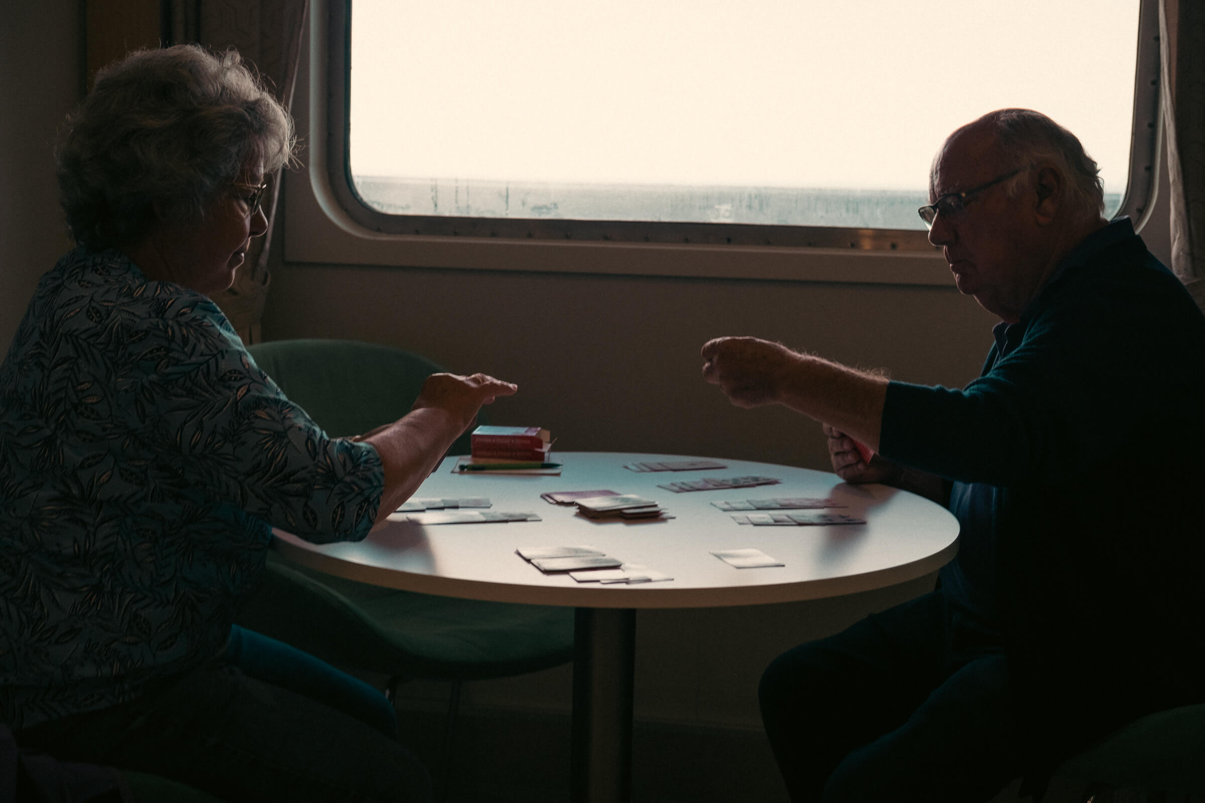 Los juegos de mesa lo petan en los viajes en ferry de las islas a la península. Una pareja de personas mayores jugando a las cartas durante el viaje