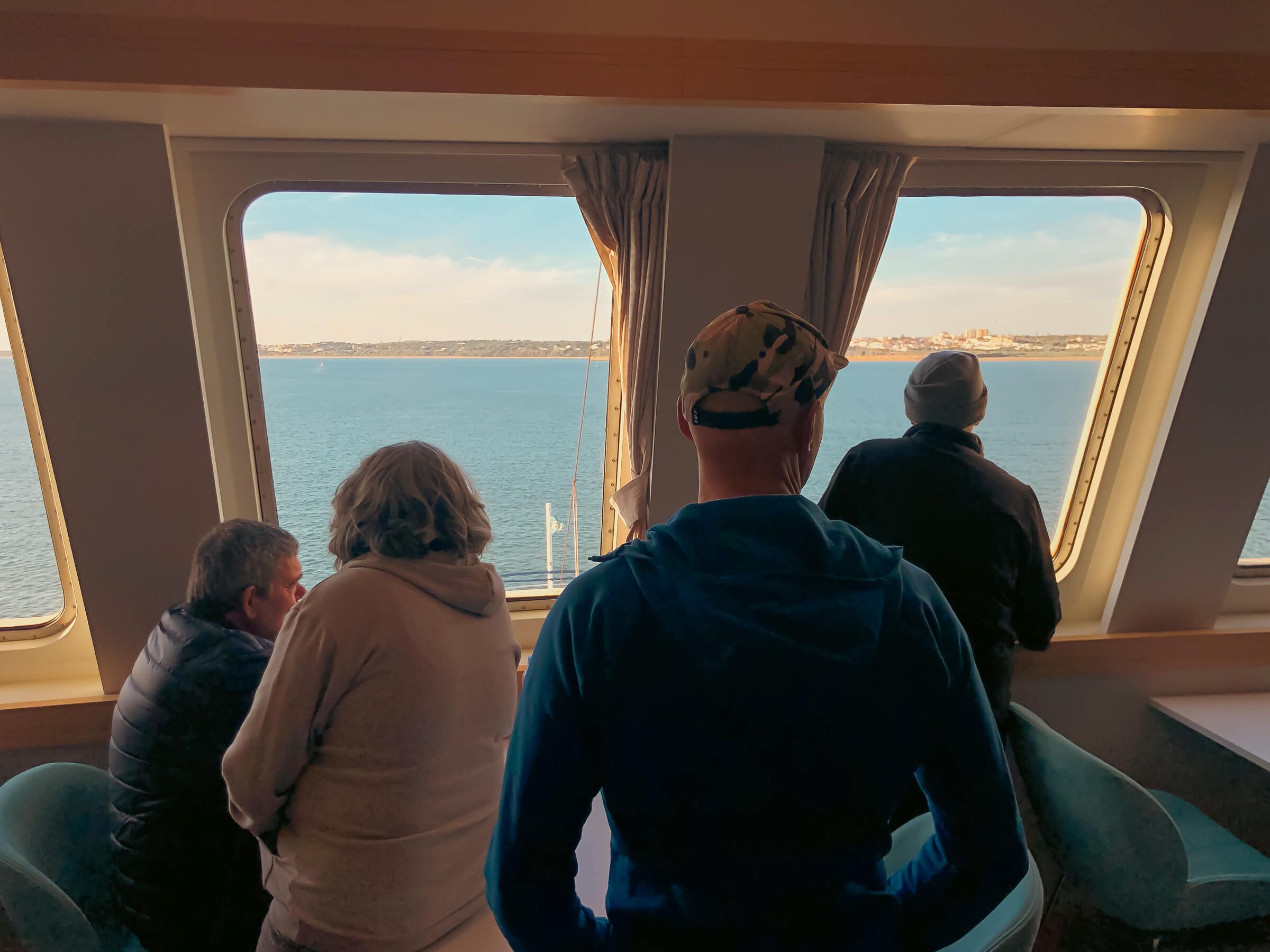Parecía que no llegábamos nunca, pero finalmente... ¡Tierra a la vista! Grupo de personas en la proa del buque viendo la llegada a la península